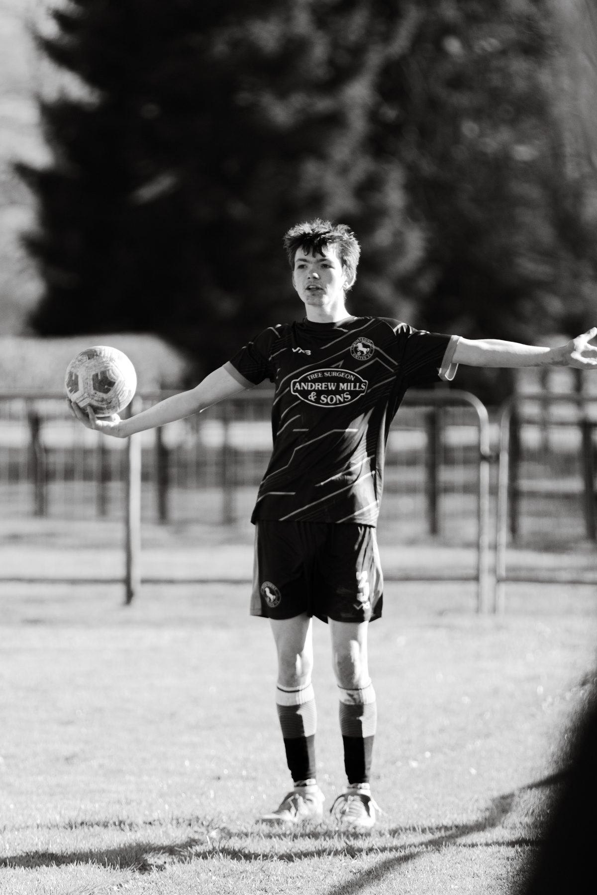 Player standing with the ball in one hand, arms wide