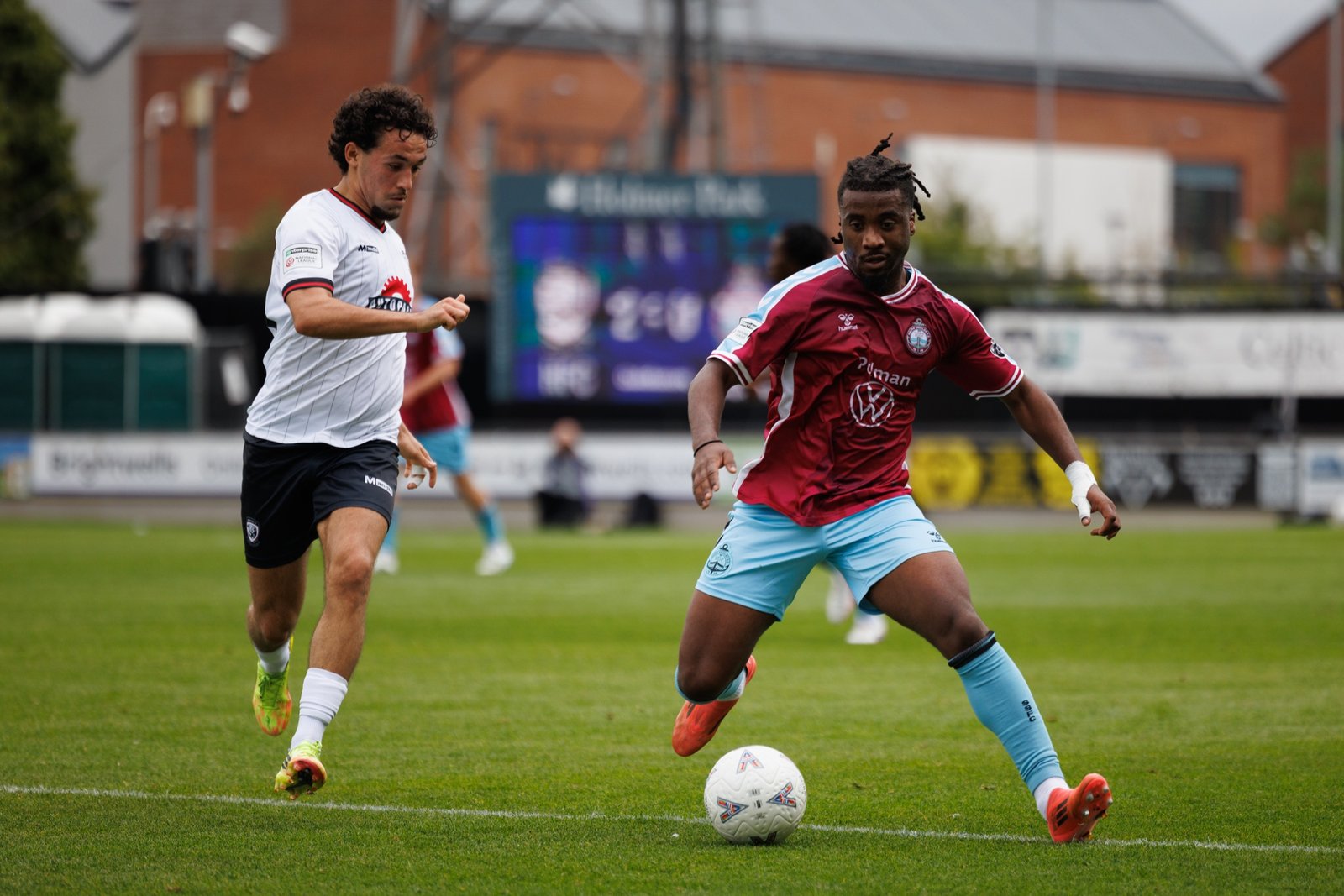 Hereford FC player tracking an opponent breaking forward with the ball