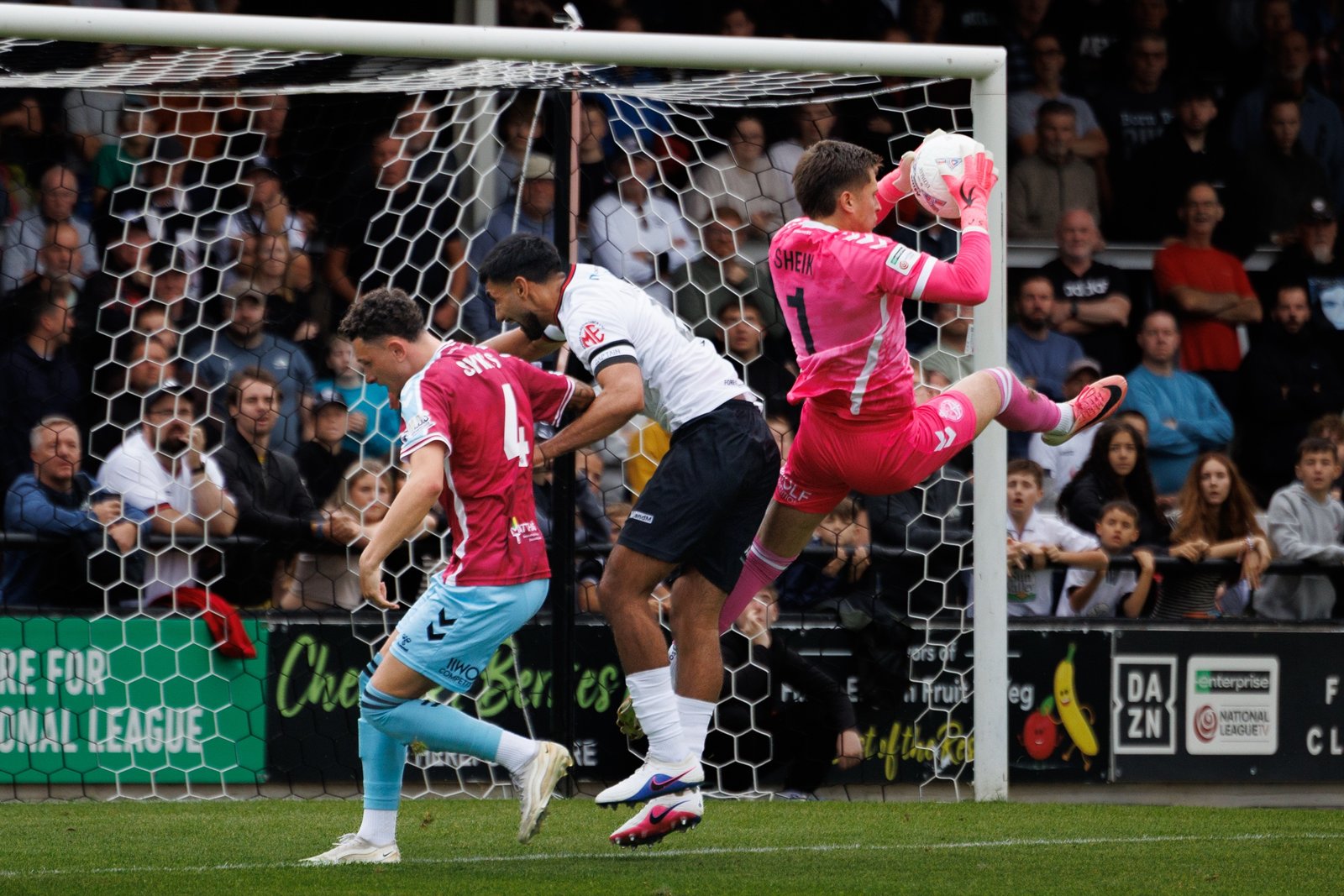 Goalkeeper claiming the ball under pressure in a crowded goalmouth