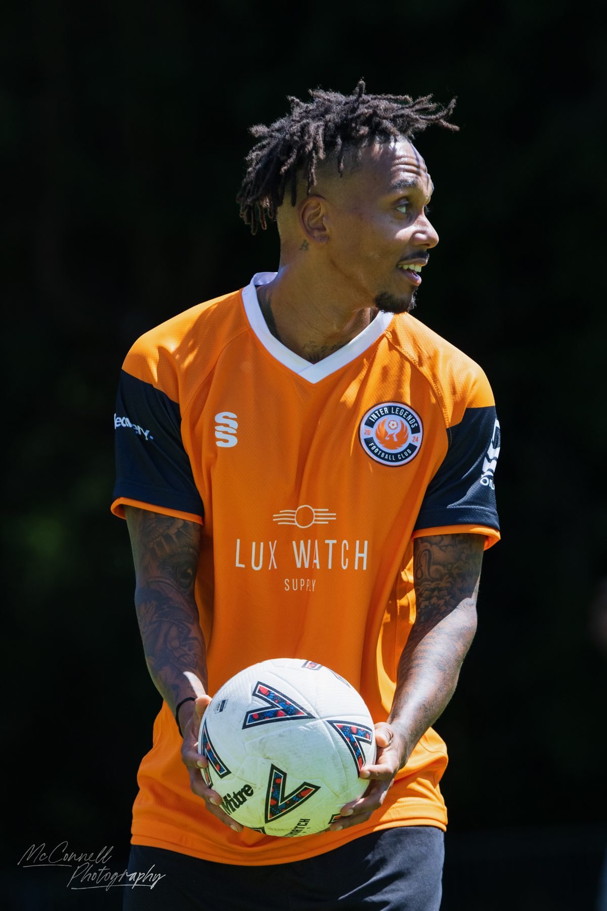 Player in an orange kit holding the ball ready for a throw-in