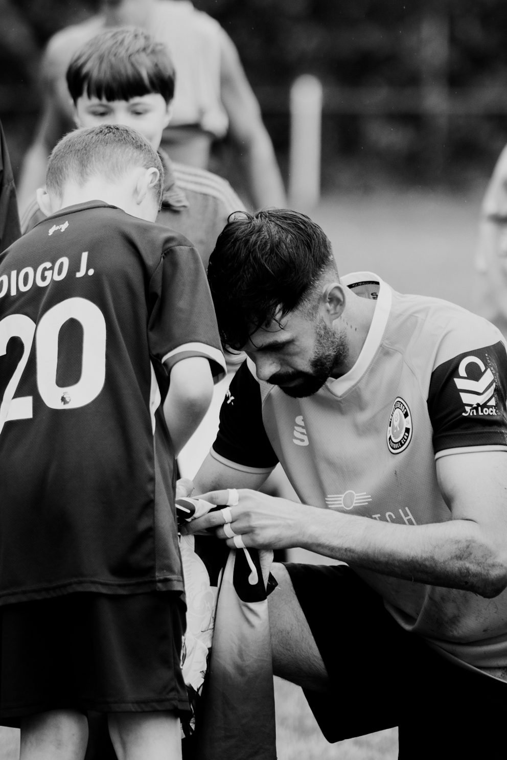 A player signing a shirt for a young supporter after the whistle