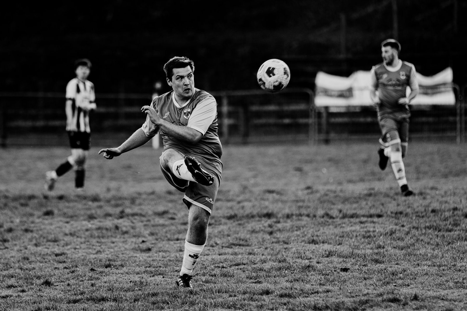 Player in yellow and black stripes running with the ball, hills behind